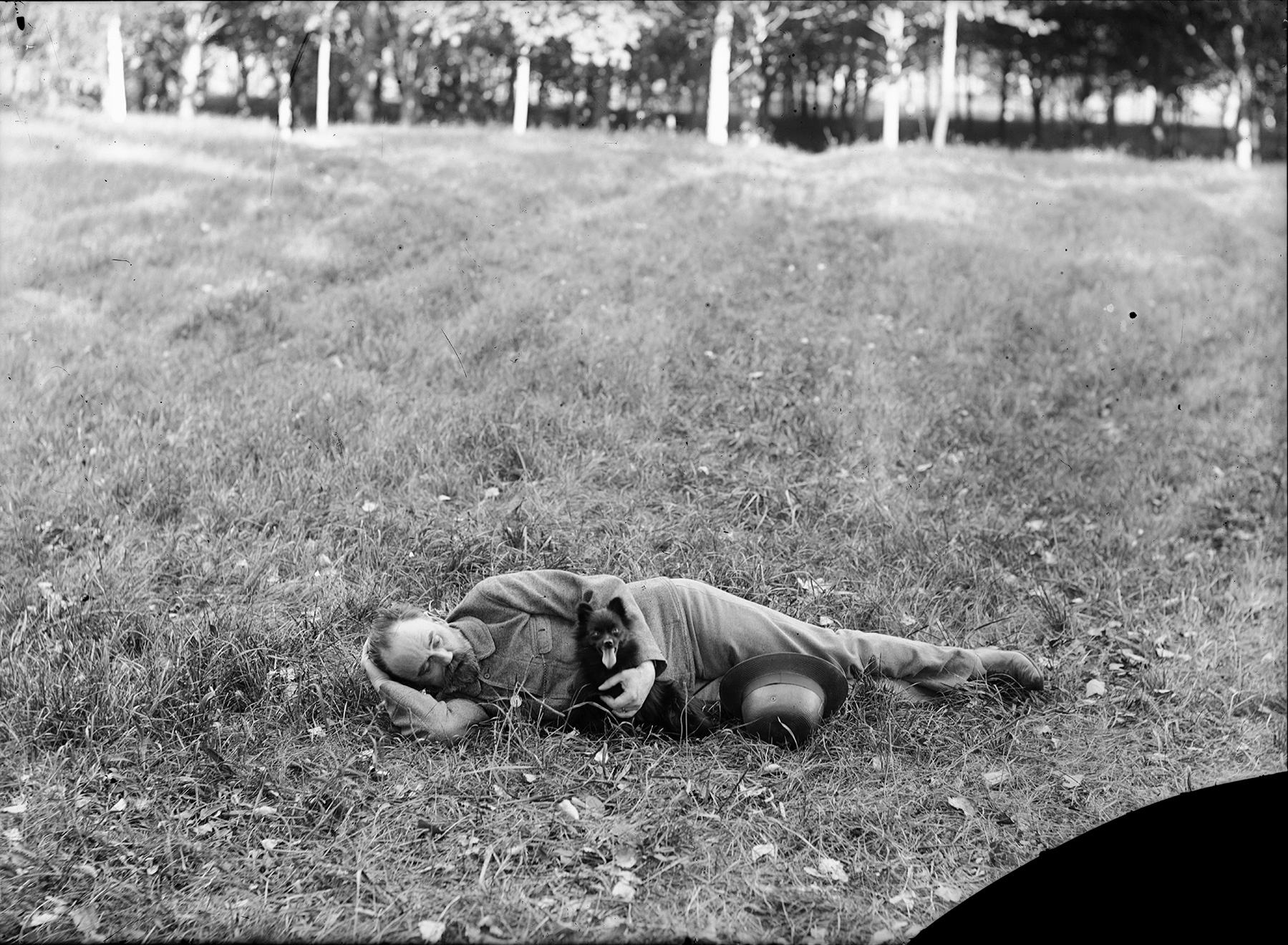 Emile Zola allongé sur l’herbe en compagnie du chien Pinpin