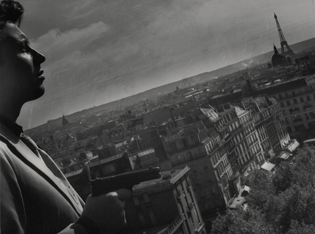 Michel Auclair de profile. Les toits de Paris en fonds.