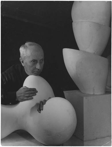 [ Jean Arp, de trois-quarts, le menton appuyé sur une sculpture ], 1954