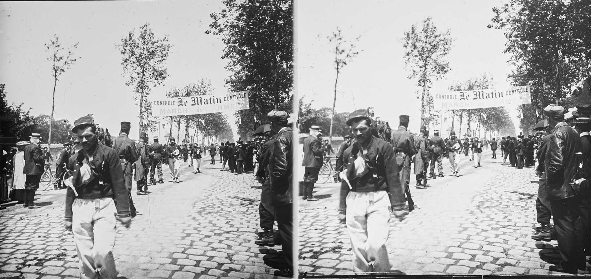 Jules Benoit-Lévy, Soldats défilant, une banderole portant l'inscription 'Le Matin Marche de l'Armée', Paris, 1905