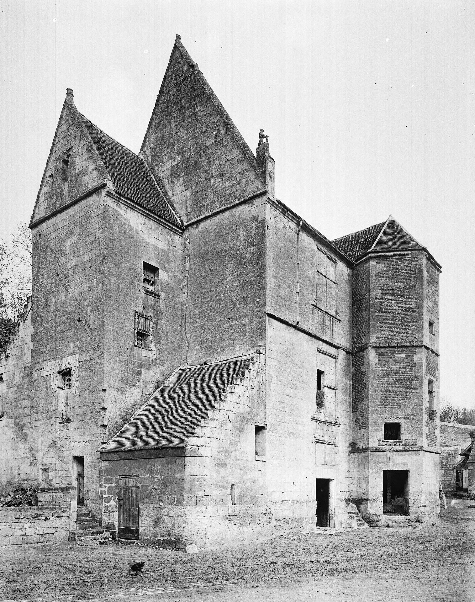 Photographie en noir et blanc. Vue d'angle d'un logis médiéval.