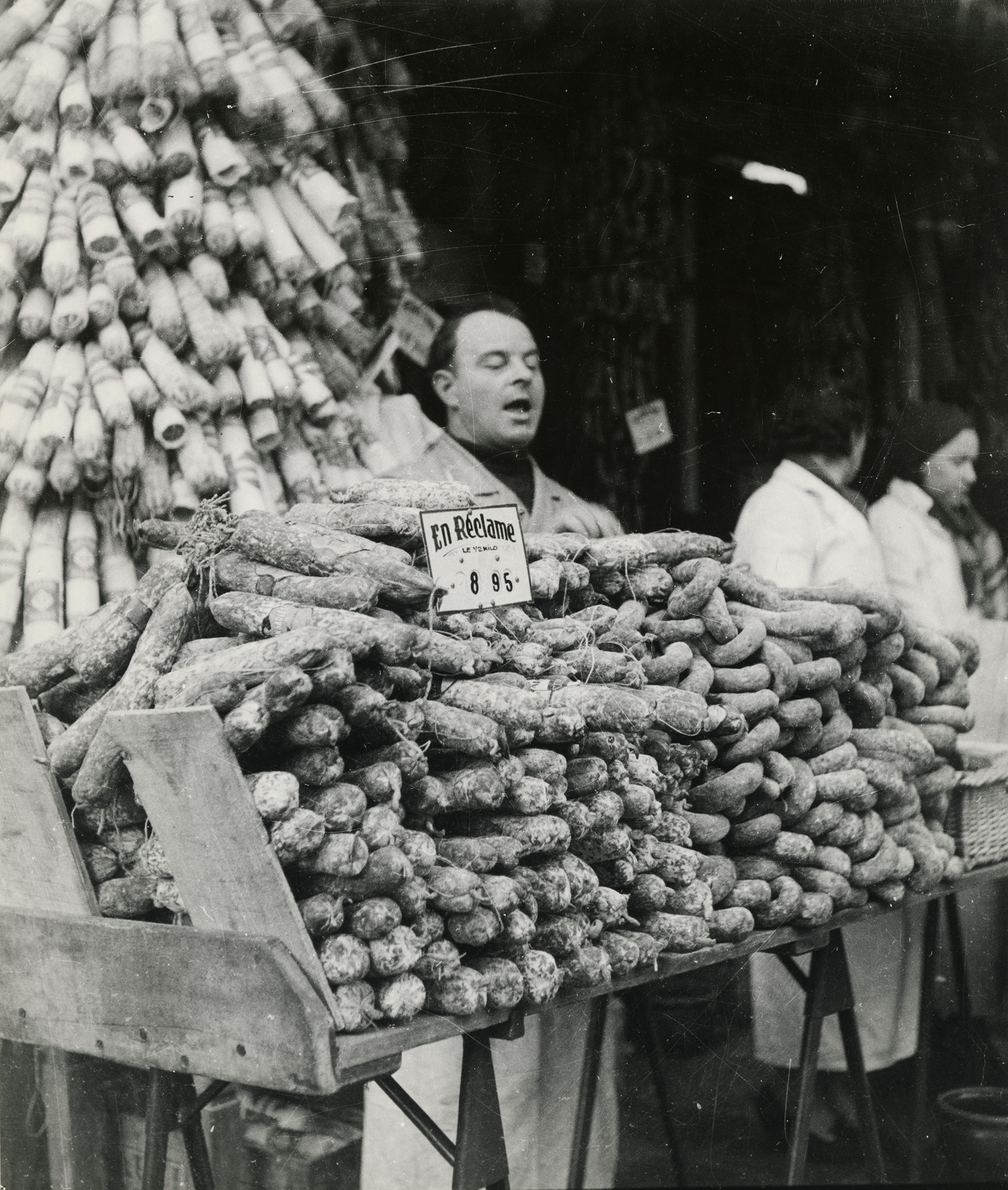 Jean Roubier, Charcutier interpelant le chaland à son étal de saucissons, Paris 