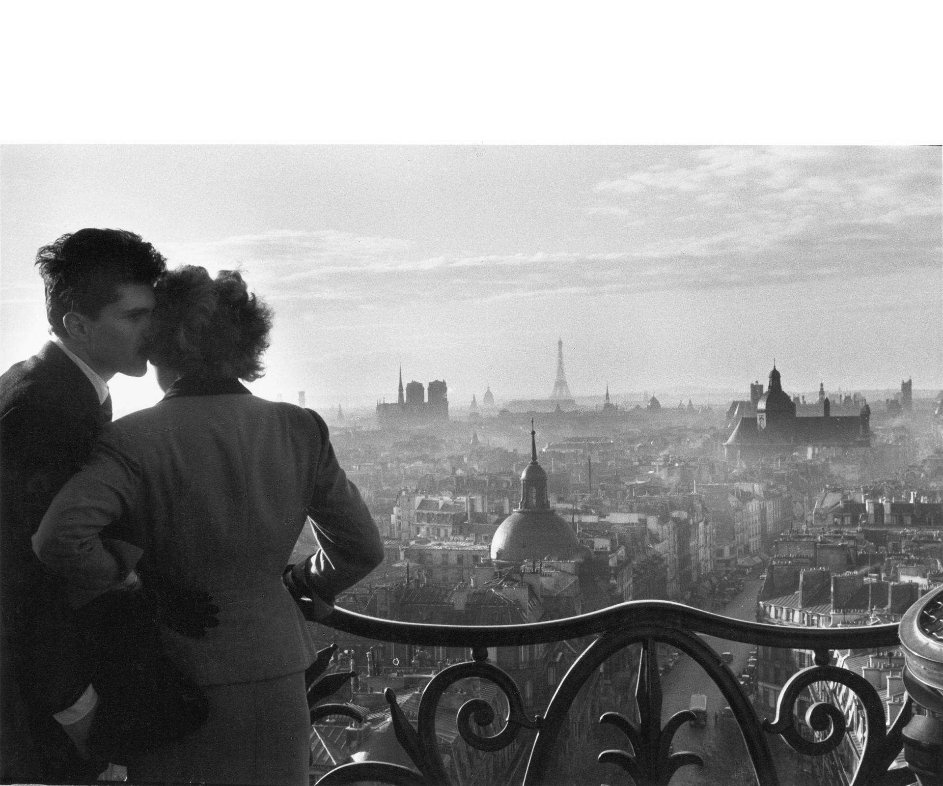 Un homme et une femme, de dos, regarde Paris depuis le haut de la colonne de Juillet, Place de la Bastille.